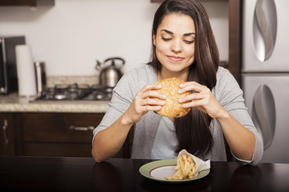 Žena jede hamburger | Author: Thinkstock