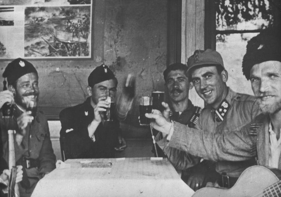 Četnici, narednik Domobranstva NDH i Ustaške vojnice nazdravljaju oko 1942. (Lijevo, sa šubarom, Uroš Drenović) | Author: Wikipedia