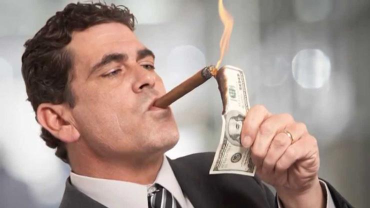 Bogataš pripaljuje cigaru dolarima