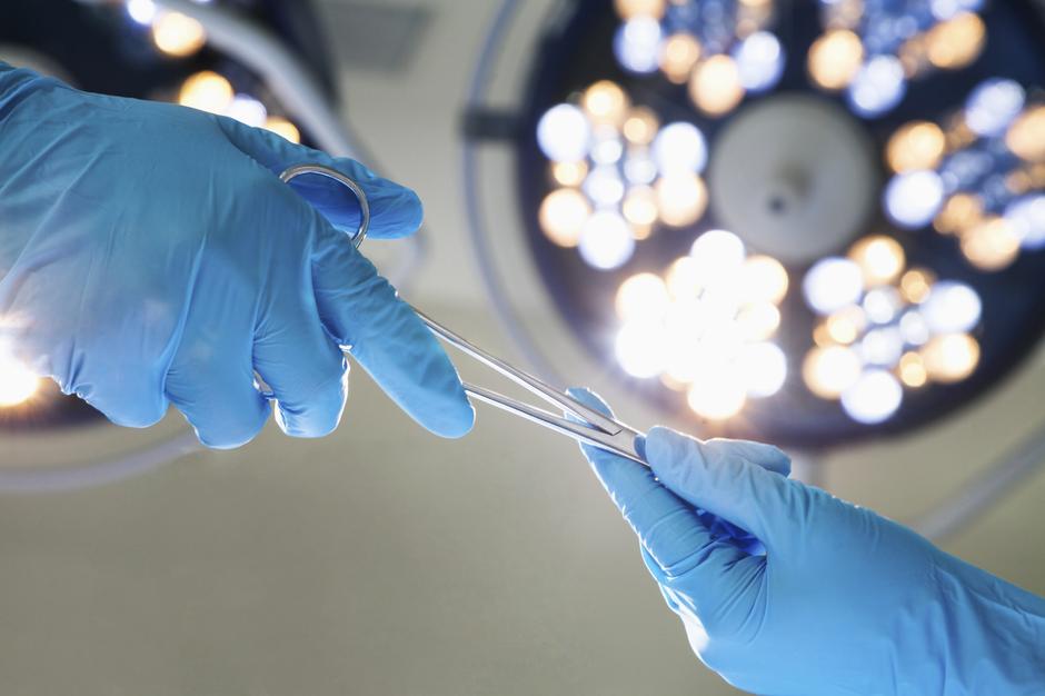 Kirurzi koji si dodaju instrumente u sali | Author: Thinkstock