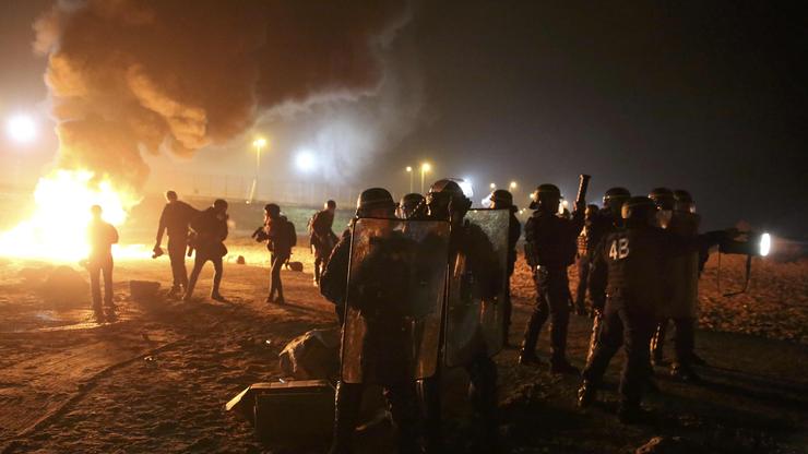 Policajci i migranti nakon što su im 2016. spalili naselje Džungla kod Calaisa