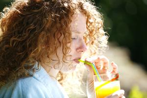Žena pije sok od naranče